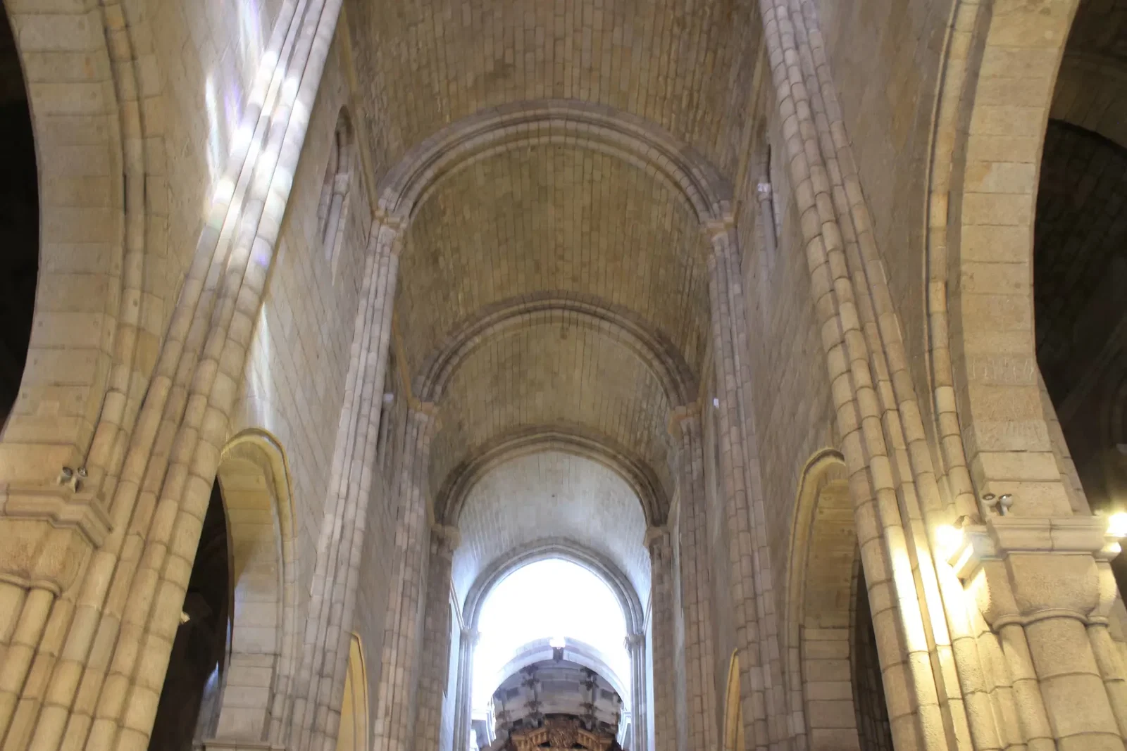 The narrow Romanesque nave of Porto Cathedral with barrel vaulting and heavy stone pillars