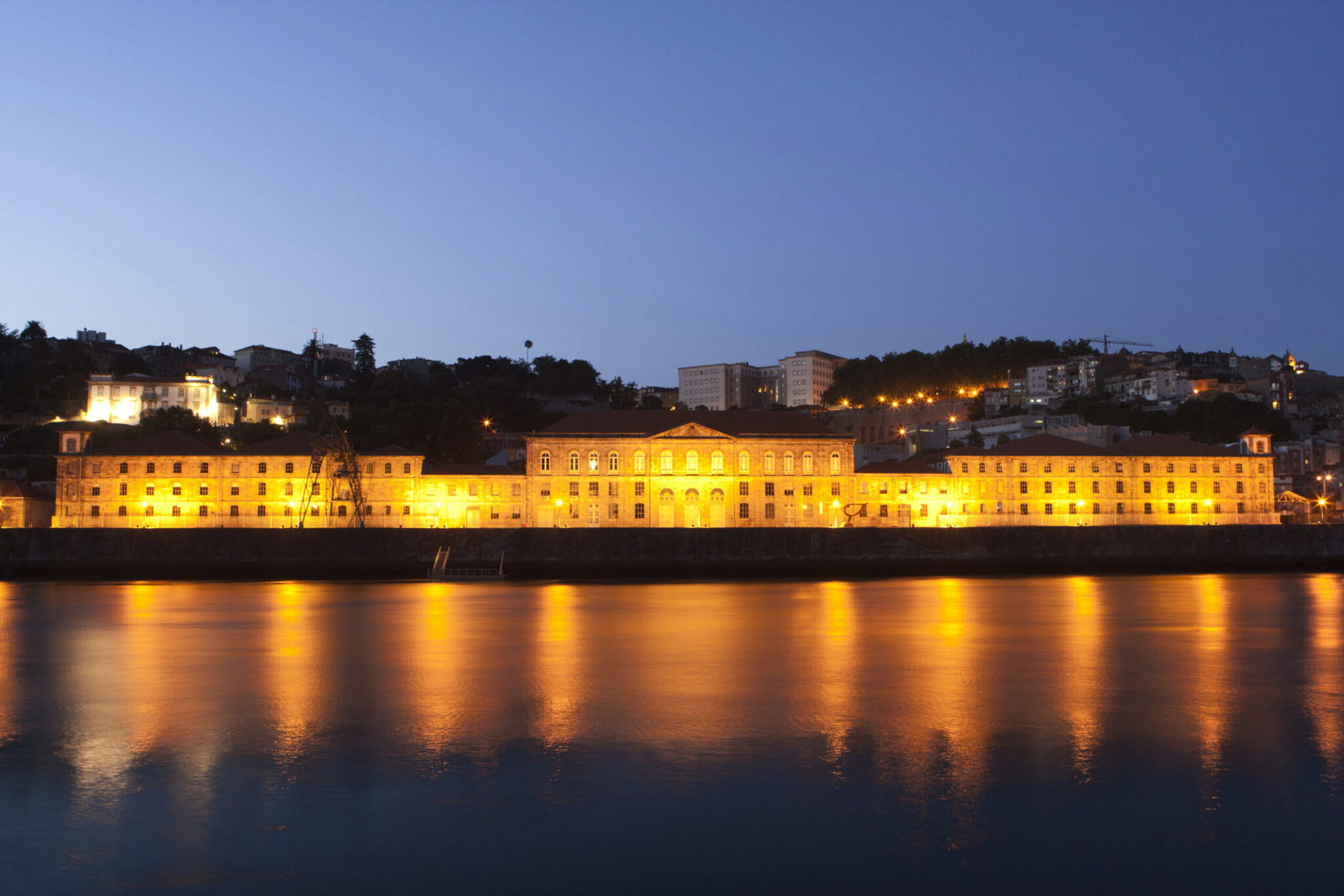 The Alfandega do Porto congress centre lit up at dusk on the Douro, home of the Porto Marathon Expo