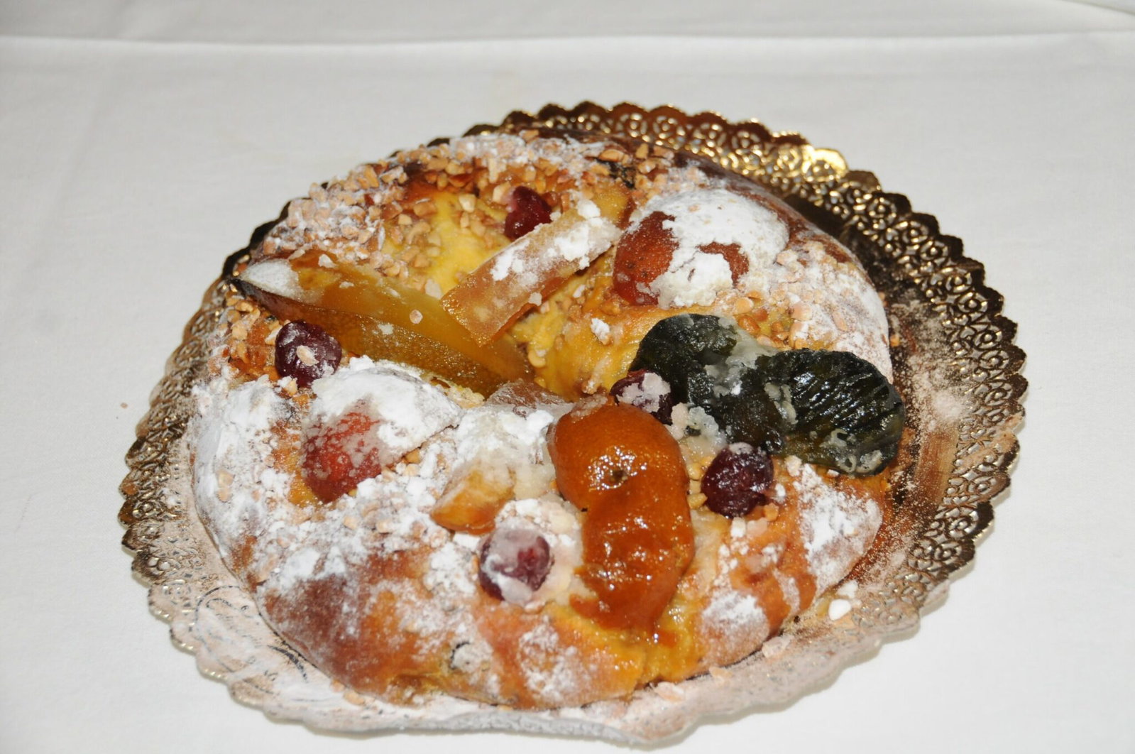 Un Bolo Rei, le gâteau des Rois portugais, garni de fruits confits, de fruits à coque et de sucre glace