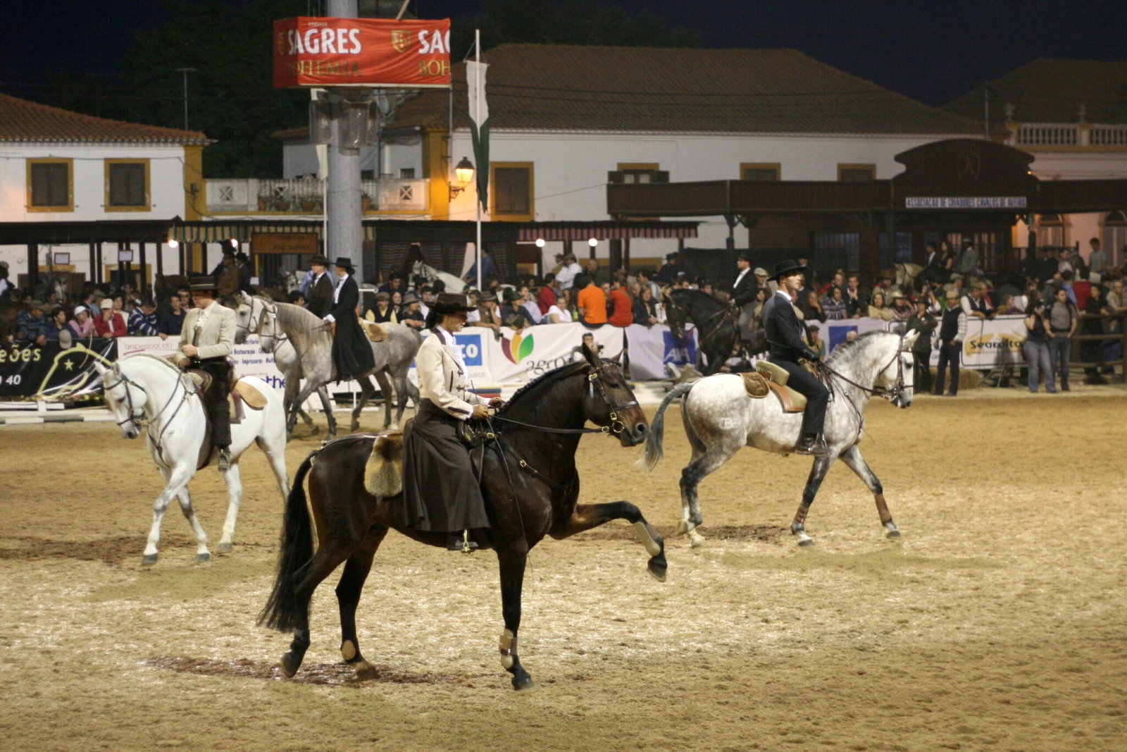 Riders on Lusitano horses in the arena at the Feira Nacional do Cavalo in Golega