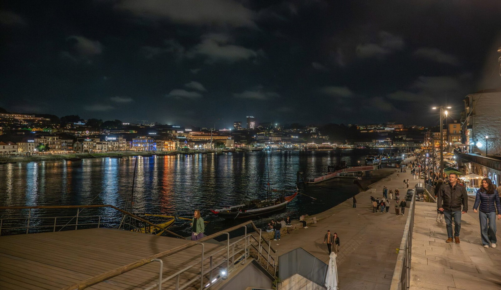 Les quais de la Ribeira à Porto la nuit, avec les lumières de la ville reflétées dans le Douro et Vila Nova de Gaia en face