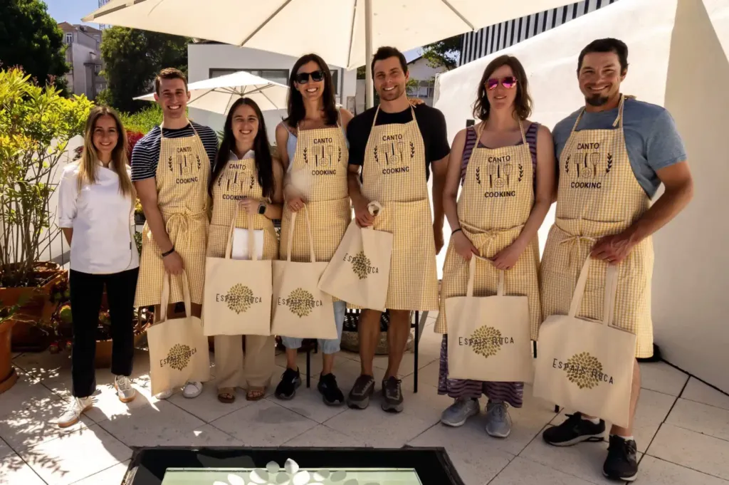 Guests in Canto Cooking aprons with their chef after a cooking class at Canto de Luz in Porto